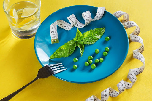 Minimal meal presentation with vegetables and measuring tape, symbolising flexible eating over strict dieting