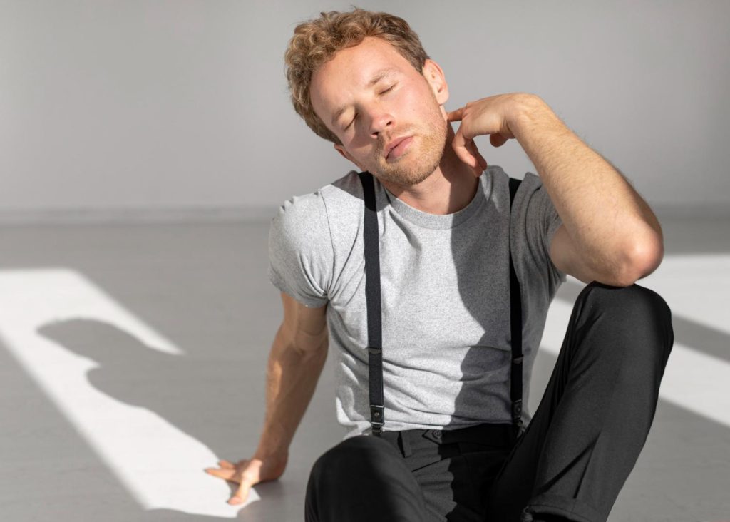 Man gently stretching his neck, illustrating muscle relaxation and daily comfort as part of a wellness routine